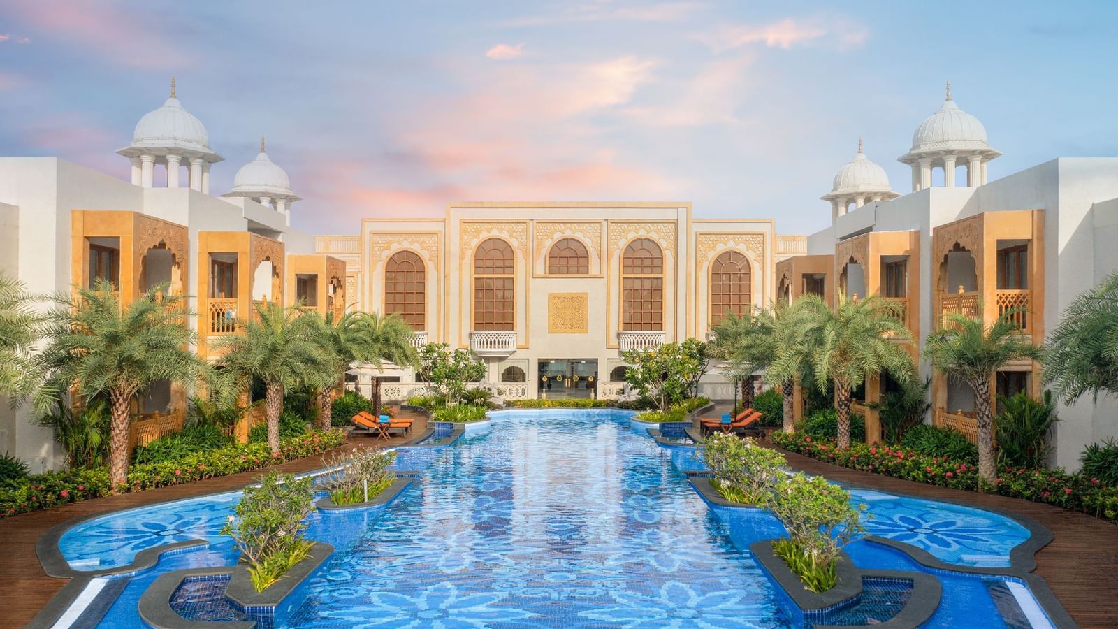 An image of our stunning palace with a swimming pool at the centre and buildings with architecture on either sides - Kaldan Samudra Palace one of the Best 5 Star Hotels in ECR | ECR Beach House with Swimming Pool